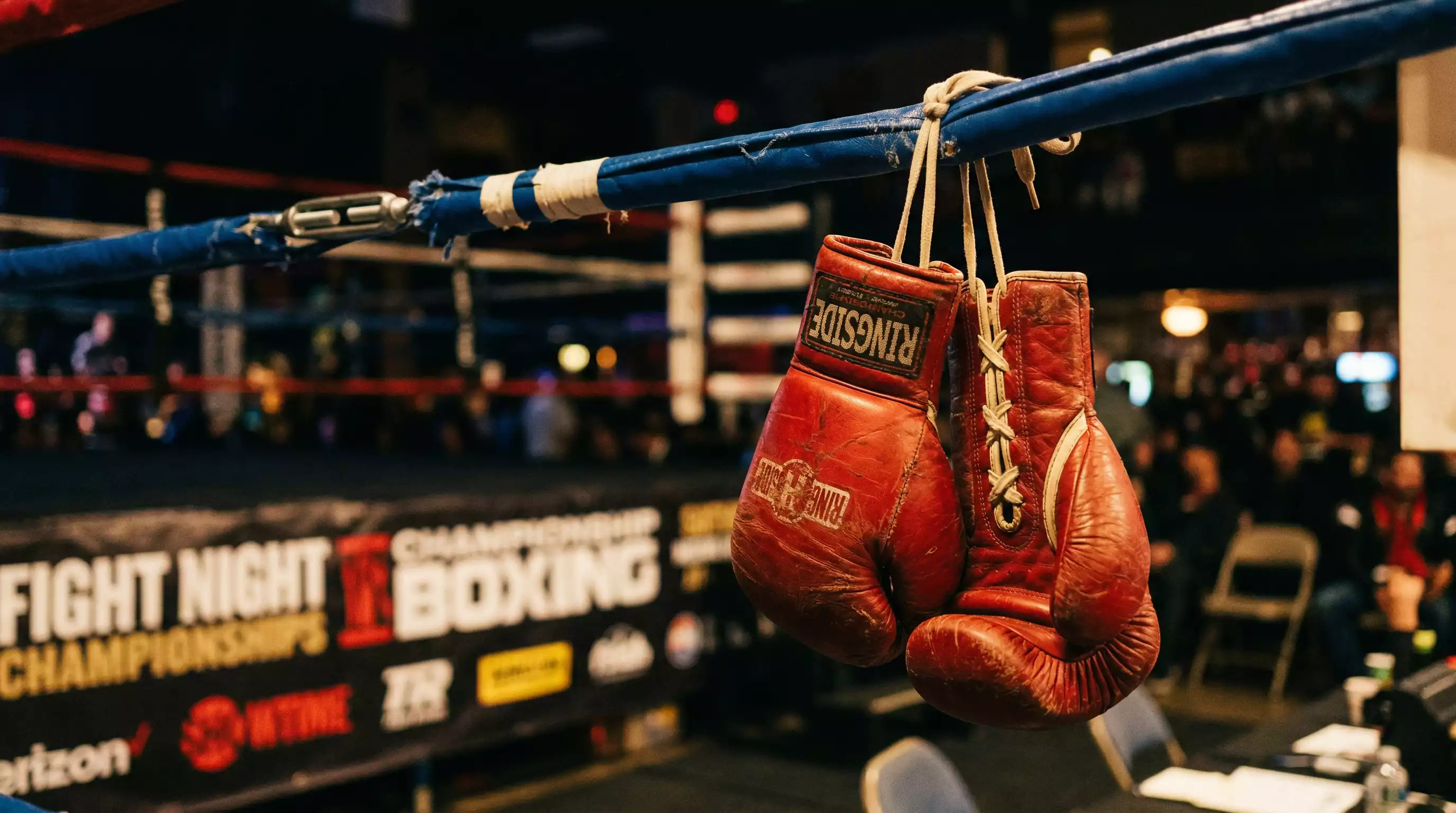 Detailaufnahme von Boxhandschuhen auf einem Werbebanner vor einem Kampf